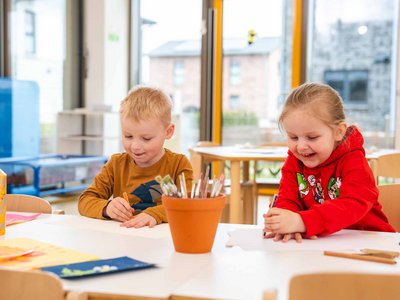 Zwei Kinder beim Malen und Gestalten an einem Tisch in der Kita Anne-Frank-Ring.