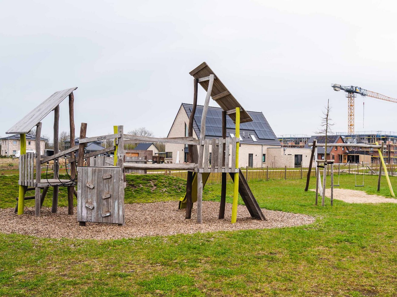 Spielplatz der Kita mit Klettergerüsten, Rutsche und Schaukeln.