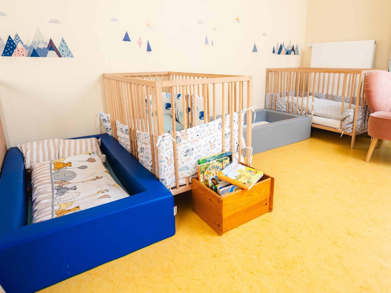 Schlaf- und Ruhebereich mit Kinderbetten und einer Bücherkiste.
